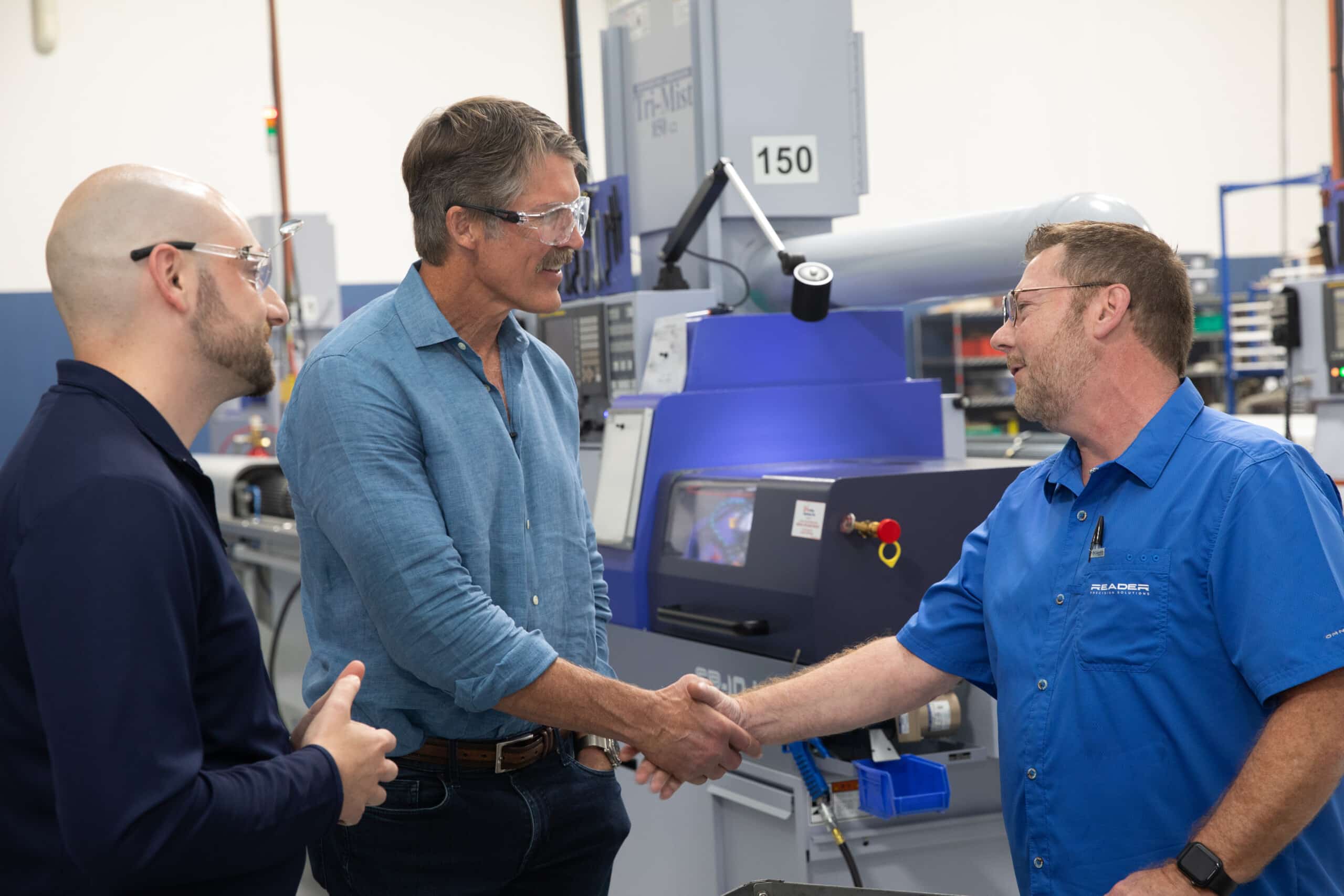 Eric Hovde shaking hands with Swiss CNC operator Brian Mullis